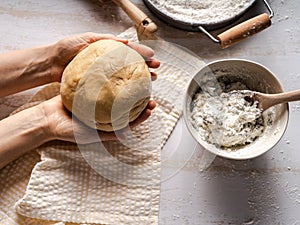 Fresh dough in woman`s hands for making ravioli or pasta with flour and ricotta
