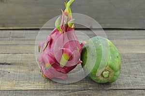 Fresh Dragon frui with papaya on wooden background