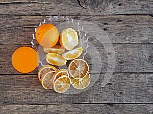 Fresh and dried orange fruit with smoothie juice on a wooden rustic background. Copy space