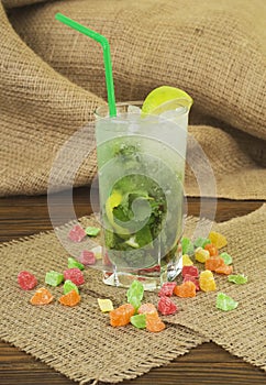 Fresh drink lemonade mojito in a glass on wooden background.