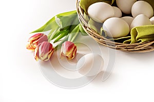 Fresh easter eggs in a basket and red tulips as a holiday corner