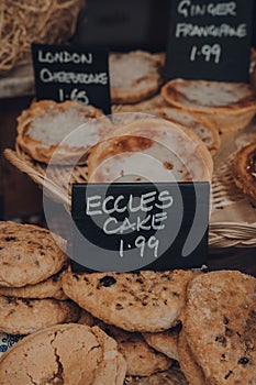 Fresh eccles cakes on a retail display of a bakery in Frome, UK
