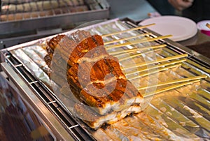 Fresh eel parts on skewers, ready for grill - streetfood in Japan