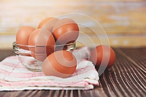 Fresh egg bowl on tablecloth on the wooden table background - Raw chicken eggs collect from the farm products natural eggs for