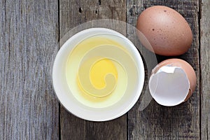 Fresh egg in bowl on wooden background