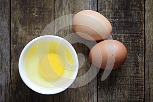 Fresh egg in bowl on wooden background