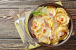 Fresh egg pasta Girasoli sunflower shaped with cheese, basil and bacon on plate. Horizontal top view photo