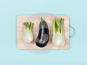 Fresh eggplant and fennels on a chopping board