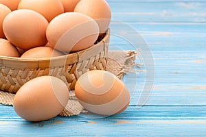 Fresh eggs in bamboo basket on blue wooden background. for food concept