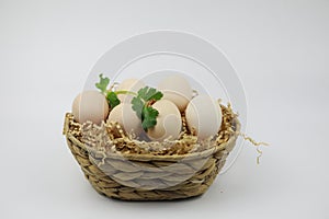 Fresh Eggs in bamboo basket with Green leaf