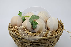 Fresh Eggs in bamboo basket with Green leaf