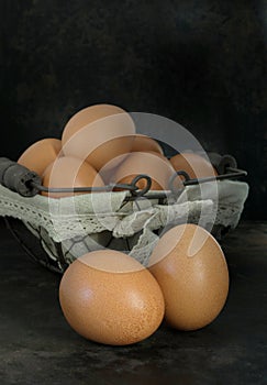 Fresh eggs in a basket on a dark background