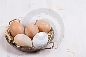 Fresh eggs in a bowl on a white background