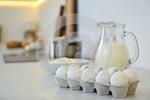 Fresh eggs and dairy products on countertop in modern kitchen. Space for text