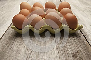 Fresh eggs in a green ceramic holder on rustic background