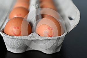 Fresh eggs with happy face in a tray