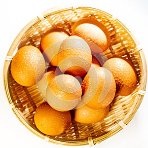 Fresh eggs with water condensation in a rattan basket. Isolated on white. Shallow depth of field