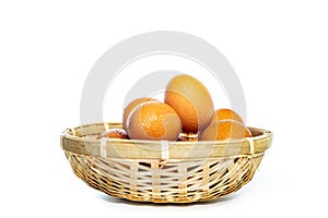 Fresh eggs with water condensation in a rattan basket. Isolated on white. Shallow depth of field