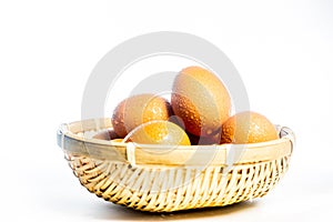 Fresh eggs with water condensation in a rattan basket. Isolated on white. Shallow depth of field