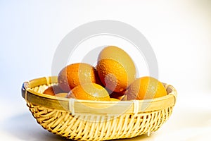 Fresh eggs with water condensation in a rattan basket. Isolated on white. Shallow depth of field