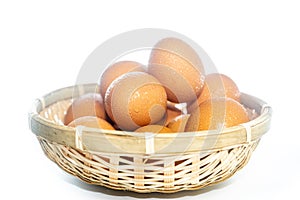 Fresh eggs with water condensation in a rattan basket. Isolated on white. Shallow depth of field