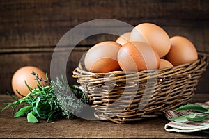 Fresh eggs in a willow basket with aromatic herbs