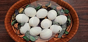 Fresh eggs in a wooden farm basket with wooden background to[ view