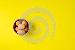 Fresh eggs on yellow background