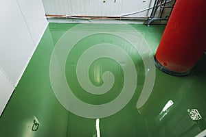 Fresh epoxy and waxed green floor newly applied in the industrial hall