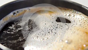 Fresh espresso coffee in a cup with foam and bubbles. Movement in slow motion.