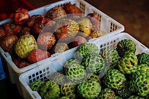 Fresh Exotic Fruits On Traditional Asian Market. Red and green sugar apples in the market.
