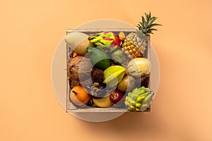 Fresh exptic fruits in wooden box top view. Fruit dragon, papaya, maracuya, kiwi, mango and granadilla in a wooden box
