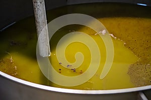 Fresh extra virgin olive oil pouring into tank at a cold-press factory
