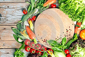 Fresh farm vegetables and herbs on rustic background.