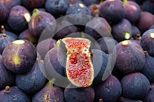 Fresh fig open in half on top of full purple ones