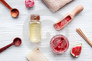 Fresh fig for organic scrub and oil in cosmetic spa set on white wooden background flat lay