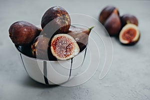 Fresh figs in bawl on gray background