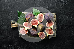 Fresh figs on black stone background. Tropical fruits. Top view.