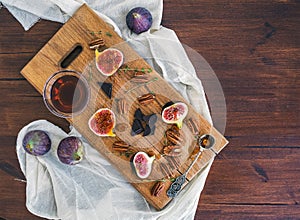 Fresh figs, chocjlate and pekan nuts with honey on a wooden boar photo