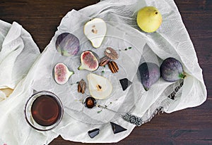Fresh figs, chocolate, pears and pekan nuts with honey on a wood
