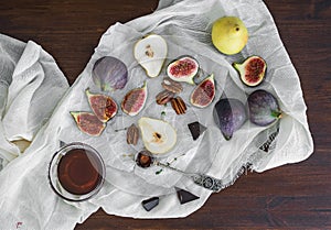 Fresh figs, chocolate, pears and pekan nuts with honey on a wood photo