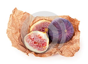 Fresh figs. Fruit and a half on craft wrapping paper isolated on white background. With clipping path.