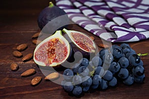 Fresh figs with grapes and almonds on a wooden table