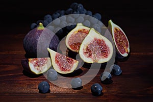 Fresh figs with grapes on a wooden table