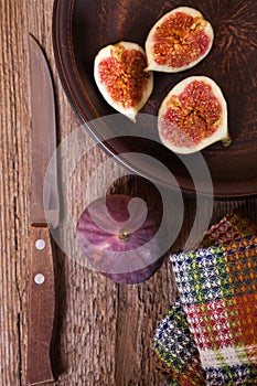 Fresh figs in a plate, old knife and towel