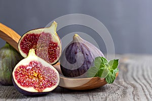 Fresh figs on the wooden table with mint leaves