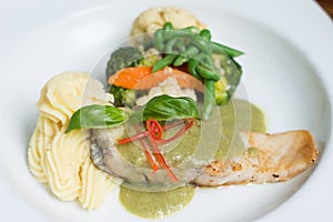 Fresh fillet of sea bass pan fried in lemon caper sauce served with mashed potatoes and green vegetables