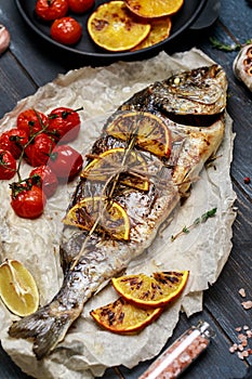 Fresh fish dorado. Raw dorado fish and ingredient for cooking. Fresh fish gilt-head bream dorade with salt, herbs and pepper.