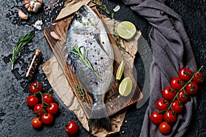 Fresh fish dorado. Raw dorado fish and ingredient for cooking. Fresh fish gilt-head bream dorade with salt, herbs and pepper.