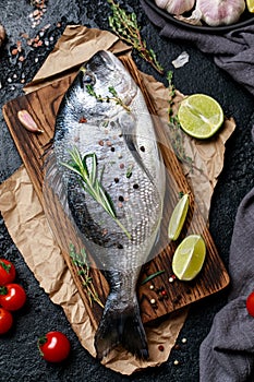 Fresh fish dorado. Raw dorado fish and ingredient for cooking. Fresh fish gilt-head bream dorade with salt, herbs and pepper.